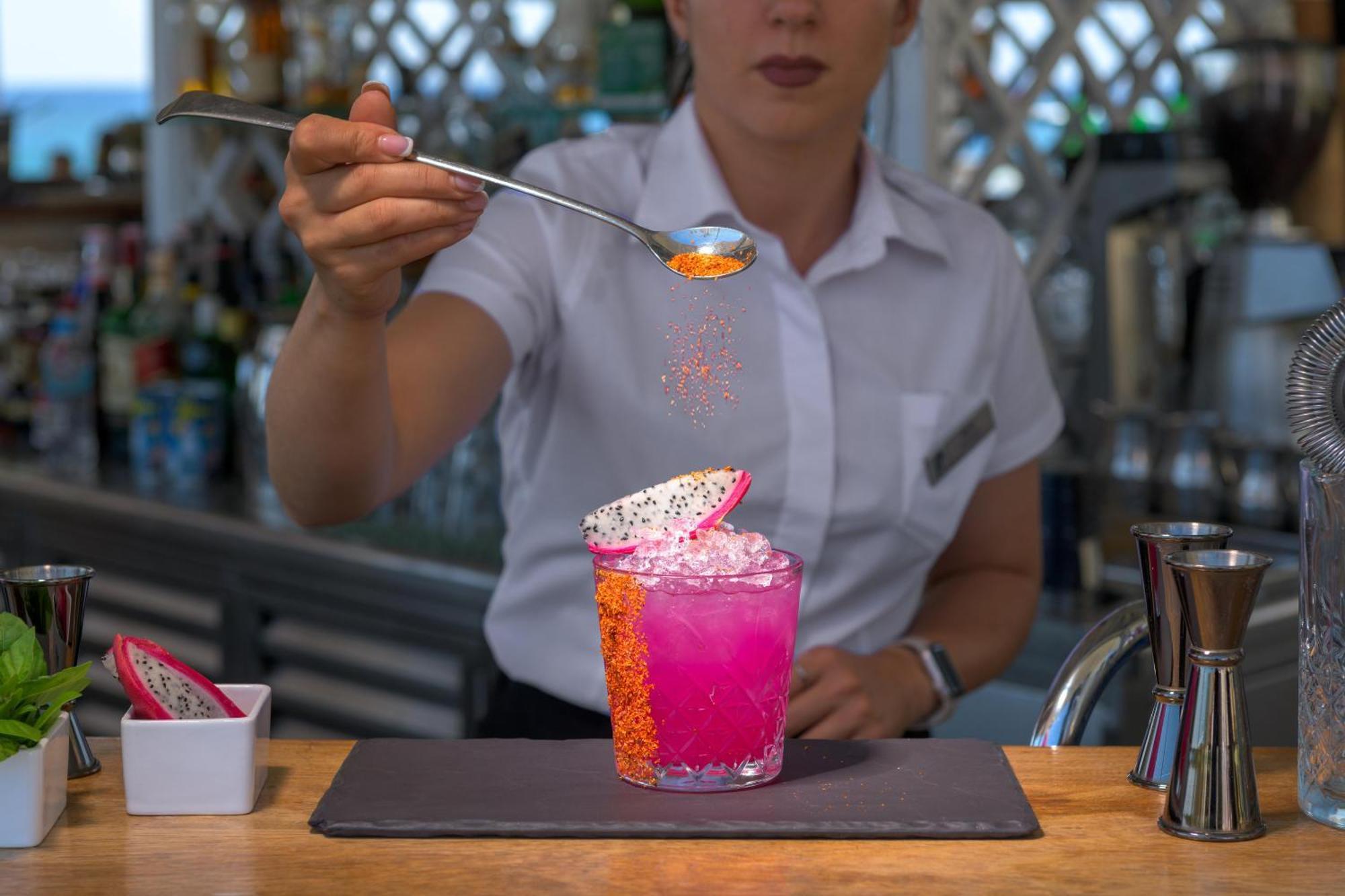 فندق رودوس بالاديوم ليجر آند ويلنيس Kallithéa المظهر الخارجي الصورة A bartender adding a garnish to a cocktail